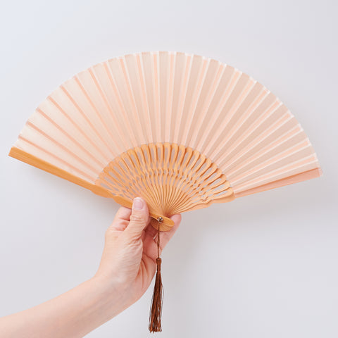 Left-handed folding fan with silk fabric and light brown bamboo ribs, includes cloth case and wooden gift box.