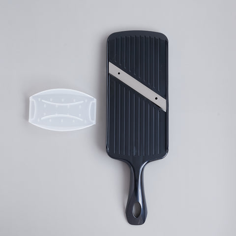 Left-handed vegetable slicer with stainless steel angled blade and safety holder, made in Japan.