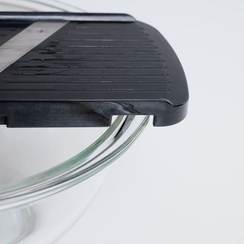 Left-handed vegetable slicer with stainless steel angled blade and safety holder, made in Japan.