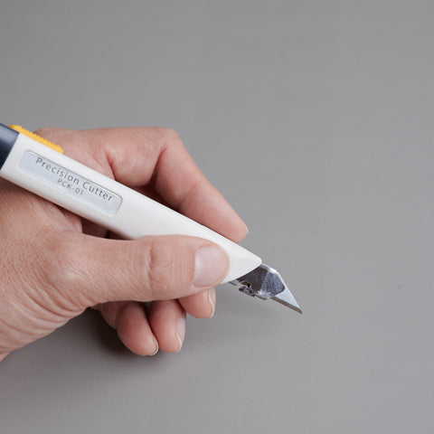 Precision utility knife with 30-degree blade, ergonomic grip, suitable for both left- and right-handed users, designed in Japan.