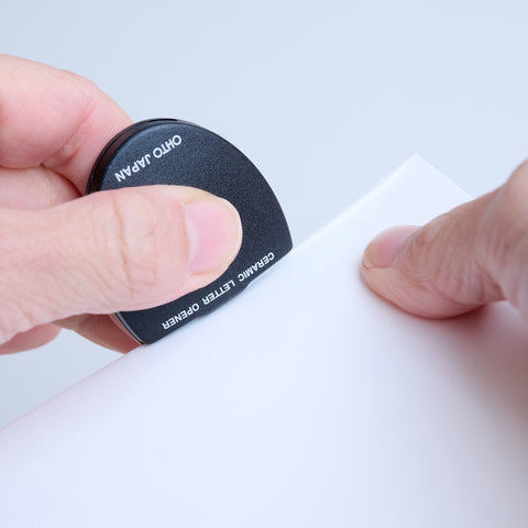 Ambidextrous letter opener with ceramic blade, 5 colors, compact and safe design.