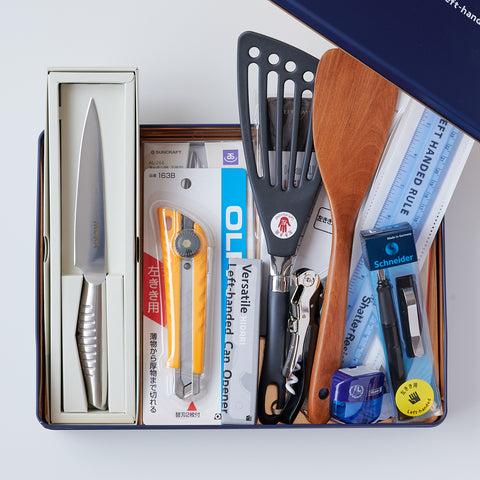 Complete gift set of left-handed tools with inch ruler, kitchenware, and stationery, packed in a designer tin box.