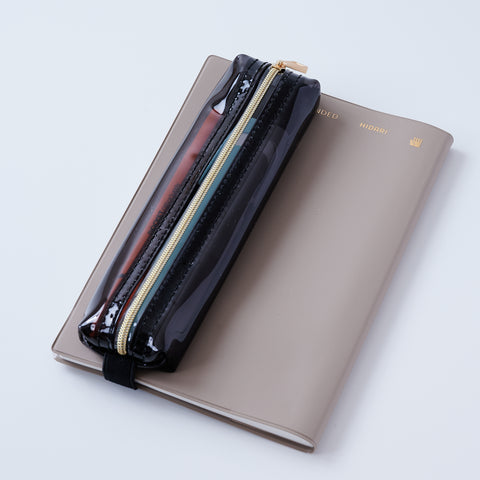 Book strap pencil case with adjustable band, clear PVC, holds 3–4 pens, Japan-made notebook accessory.