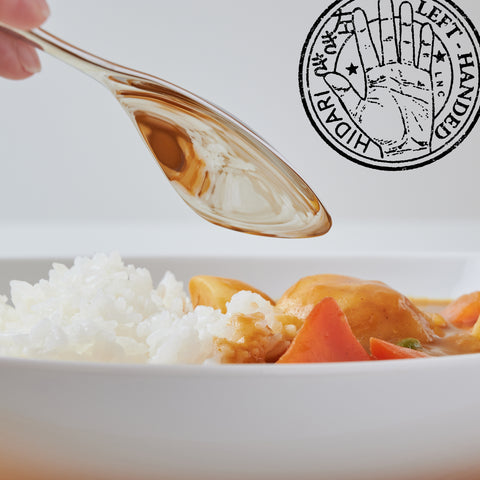 Left-handed stainless steel spoon for curry and rice, polished finish, photographed on black background.