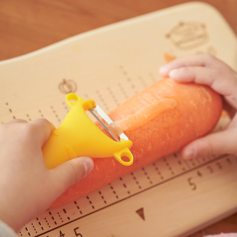 SUNCRAFT kids vegetable peeler with narrow stainless steel blade and ambidextrous handle, designed for ages 4–10, made in Japan.