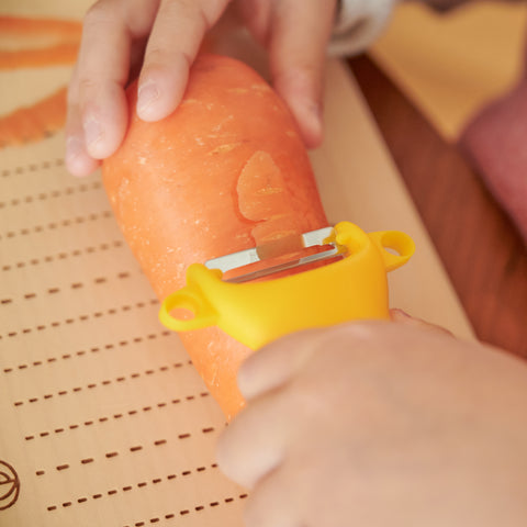 SUNCRAFT kids vegetable peeler with narrow stainless steel blade and ambidextrous handle, designed for ages 4–10, made in Japan.