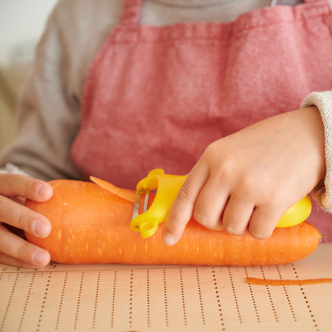 SUNCRAFT kids vegetable peeler with narrow stainless steel blade and ambidextrous handle, designed for ages 4–10, made in Japan.