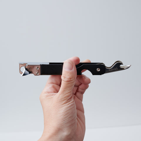 Versatile left-handed can opener with matte black finish, 3-in-1 functionality for cans, bottles, and hole punching, ergonomic design for left-handed users, made in Japan by HIDARI.