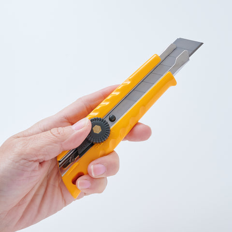 Left-handed OLFA utility knife with ergonomic design, reversed lever for smooth blade operation, includes two replacement blades, suitable for packaging, crafting, and DIY, made in Japan.