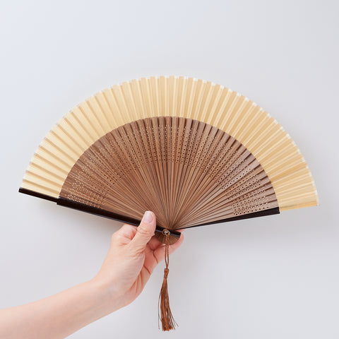 folding fan (with dark brown ribs), left-handed